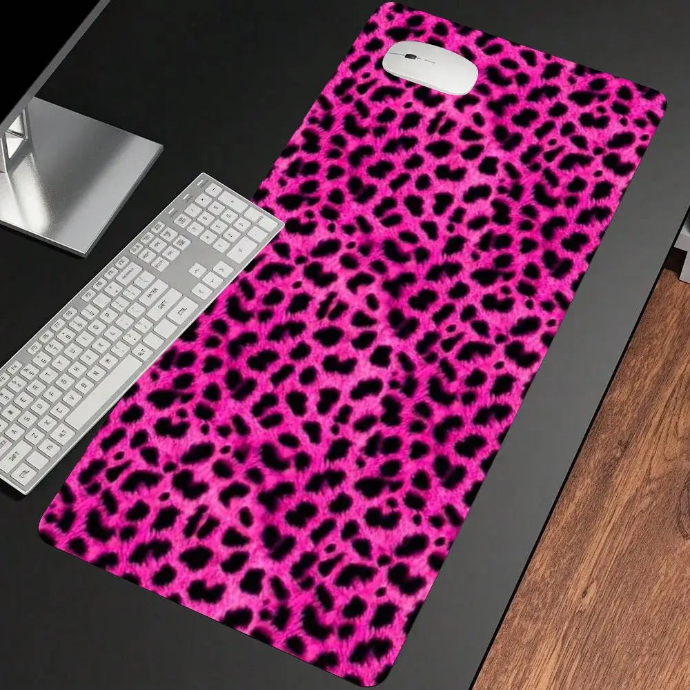 A vibrant pink leopard print non-slip gaming mouse pad with a white computer mouse resting on it.
