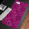 A vibrant pink leopard print non-slip gaming mouse pad with a white computer mouse resting on it.