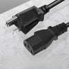 A black universal power cord adapter with a connector and cable lying on a white marble surface.