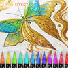 A vibrant golden glitter butterfly design on white paper with a row of dual-tip acrylic paint markers below.