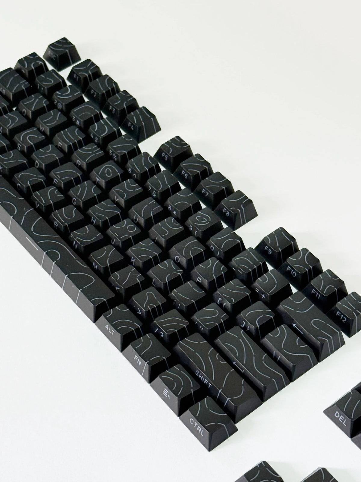 Vista cercana de teclas de contorno degradadas negras para teclado mecánico, mostrando el diseño y la textura.