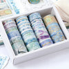 A box of oil painting themed decorative washi tape rolls in various colors and designs.