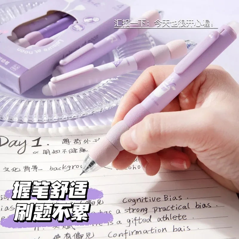 A hand holds a purple erasable gel pen with a soft grip, resting on lined paper and a box of pens.