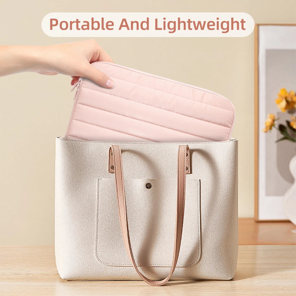 A light pink padded laptop sleeve is being placed into a beige canvas tote bag.
