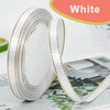 Rolls of white satin ribbon with gold edges displayed on a surface.