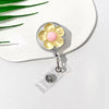 A clear retractable ID badge holder featuring a floral pull buckle with yellow and pink accents.