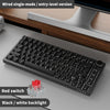 A black wired single-mode entry-level mechanical keyboard with a white backlight shown on a wooden desk.