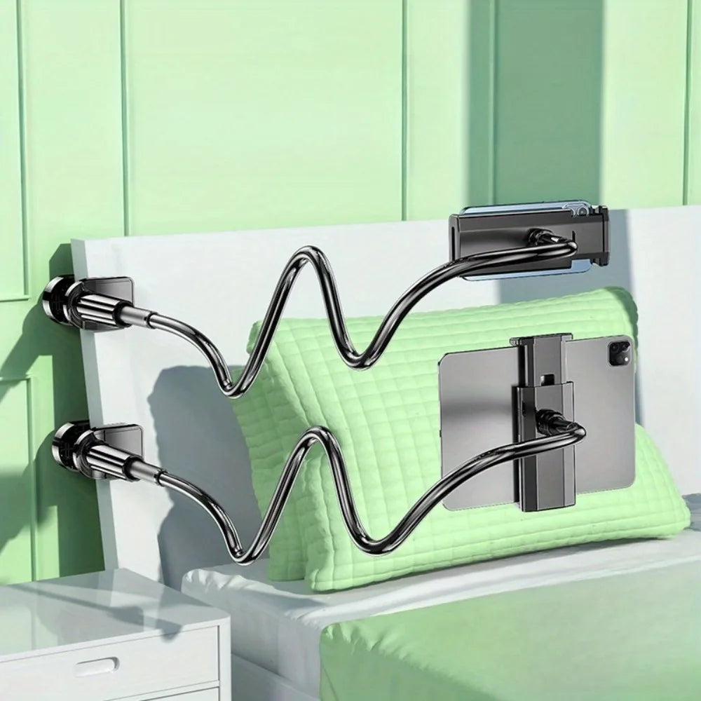 A silver rotating tablet and phone stand with a flexible spiral base resting on a light green surface.