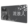 A dark gray desk mat featuring Japanese text and white cherry blossoms.