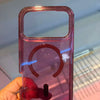 A hand holds a clear pink glitter shockproof magnetic case for an iPhone.