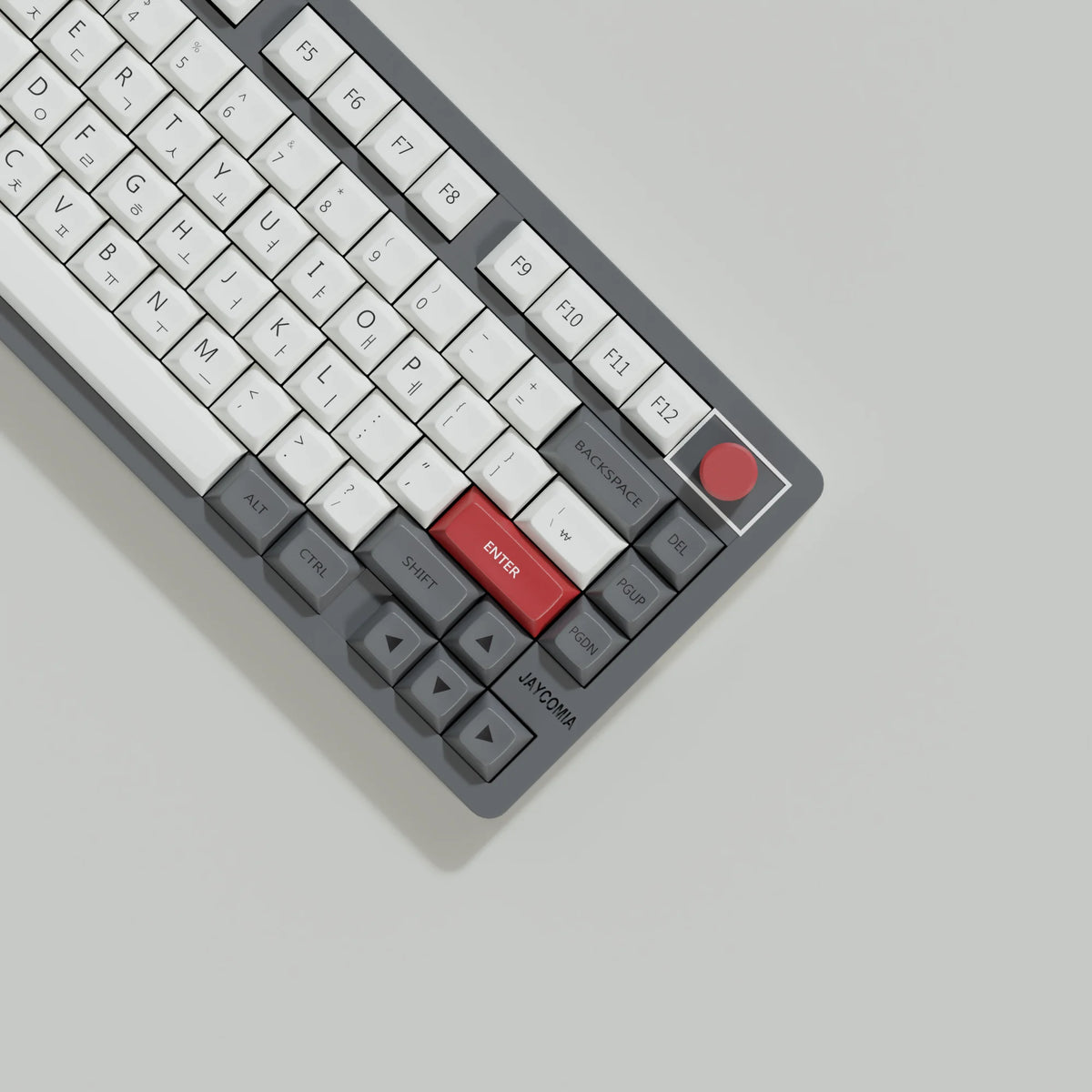 A close-up view of a gray mechanical keyboard with retro NES style PBT keycaps and red accents.