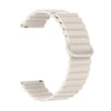 A white adjustable magnetic loop watch band shown in a curved shape.