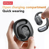 A hand holds a black open charging compartment sports earbud with a silver charging case nearby.