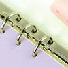 A close-up of a set of metal binder rings used for zipper pockets in a silver finish.