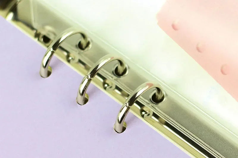 A close-up of a set of metal binder rings used for zipper pockets in a silver finish.