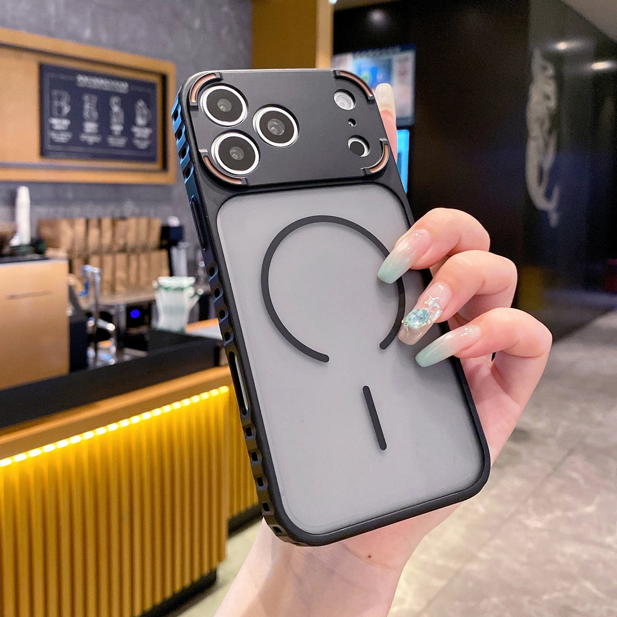 A hand holds a frosted magnetic silicone case for an iPhone, displaying the back design.
