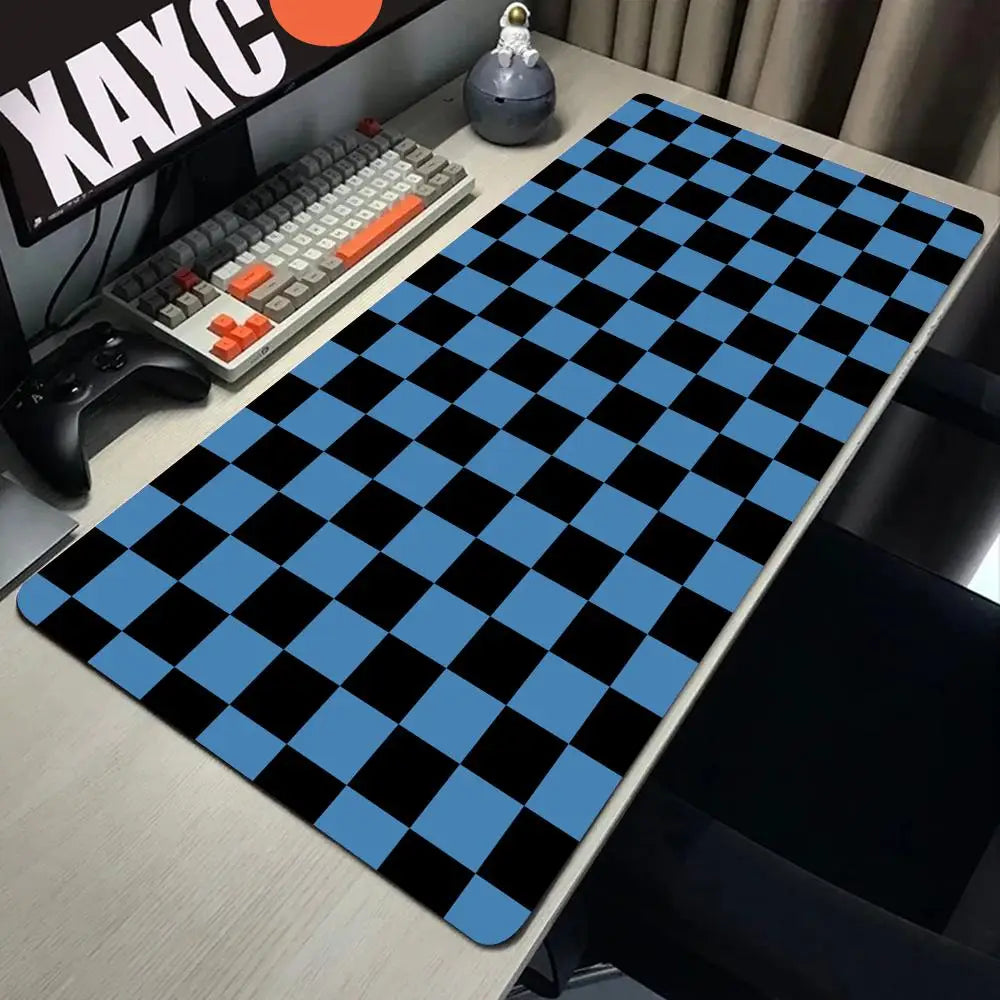 A black and blue checkered desk mat is placed on a wooden desk next to a keyboard and gaming controller.