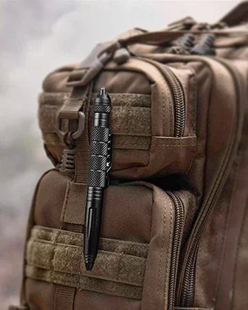 A close-up view of a brown tactical self-defense pen with a glass breaker tip inside a padded tactical bag.