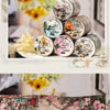 A collection of decorative washi tape rolls featuring floral designs and collage patterns for scrapbooking.
