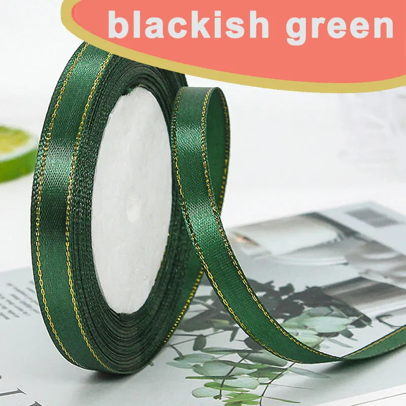 Roll of blackish green satin ribbon with gold edge visible on a surface.