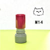 A red and gray teacher stamp with a cat face design is shown on a yellow surface.