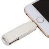 A white smartphone is shown with a metal USB flash drive attached to its charging port.
