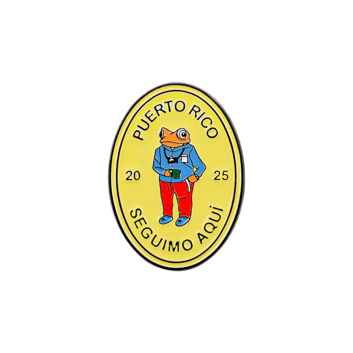 An enamel pin featuring a frog wearing a shirt and holding a small object, with the text Puerto Rico and 25 visible.