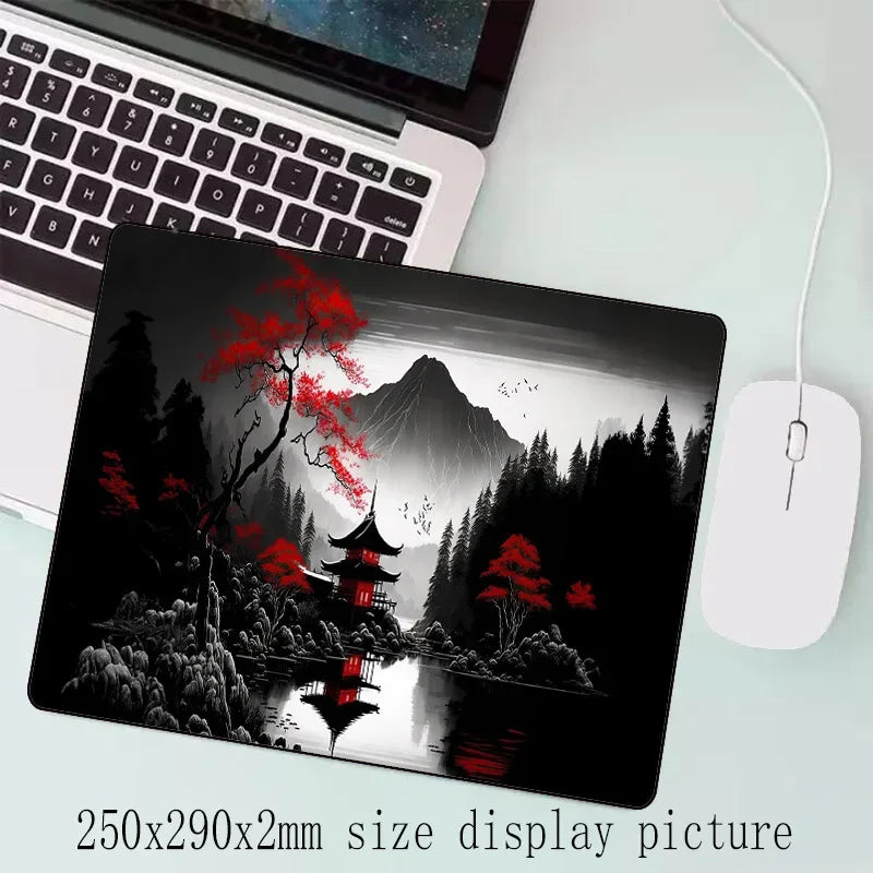 Schwarzes Laptop mit einem Displaybild eines rötblättrigen Baumes, reflektiert im Wasser vor einer nebeligen Berglandschaft.