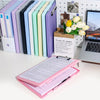 A set of colorful A4 document and photo storage file boxes lined up next to a laptop and a pink file folder.