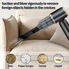 A black portable vacuum cleaner is shown suctioning foreign objects from the crevices of a beige cushion.