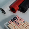 A close-up of a professional gaming mouse pad desk mat with red, black, and white colored fabric rolls.