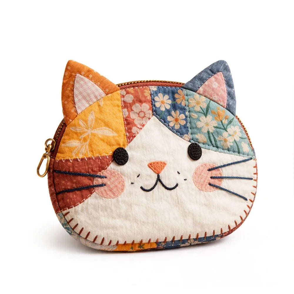 A patchwork cat face coin purse with a zipper featuring orange, blue, and white fabric patches.