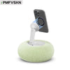 A white magnetic pillow stand holding a smartphone, featuring a green fuzzy base.