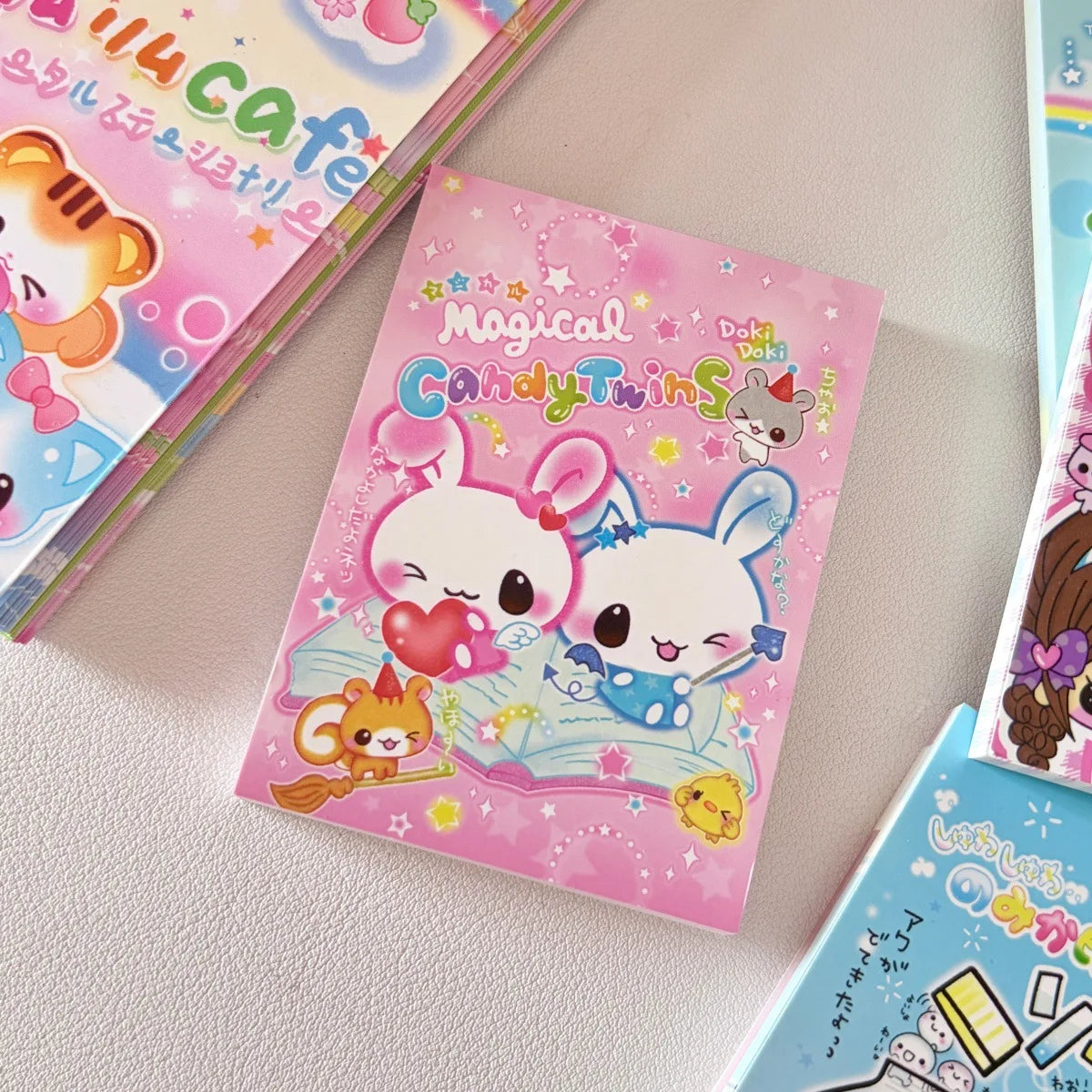 A pink memo pad featuring two cute cartoon rabbits with hearts and stars.