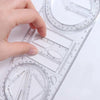 A hand is holding a clear geometric drawing ruler with rotating angles and measurement markings.