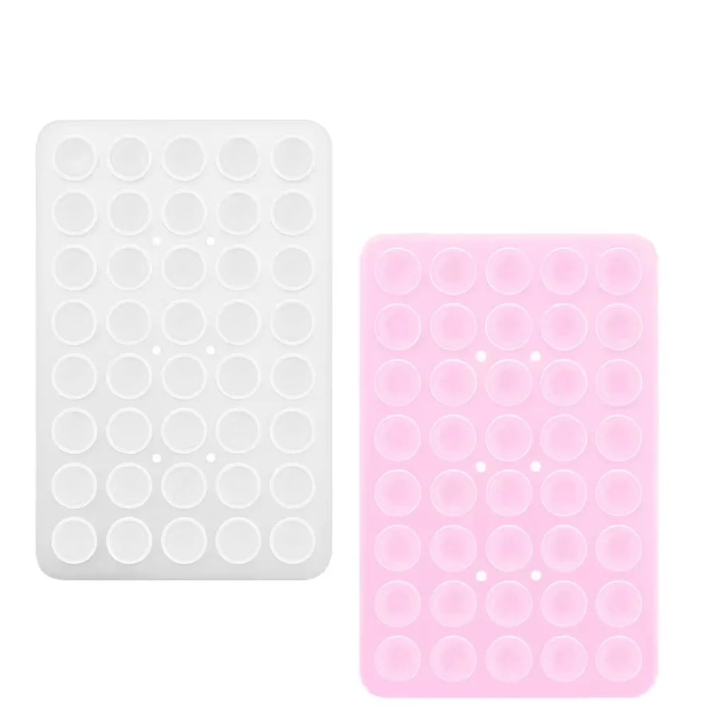 Un par de soportes para teléfono con ventosas dobles en colores blanco y rosa.