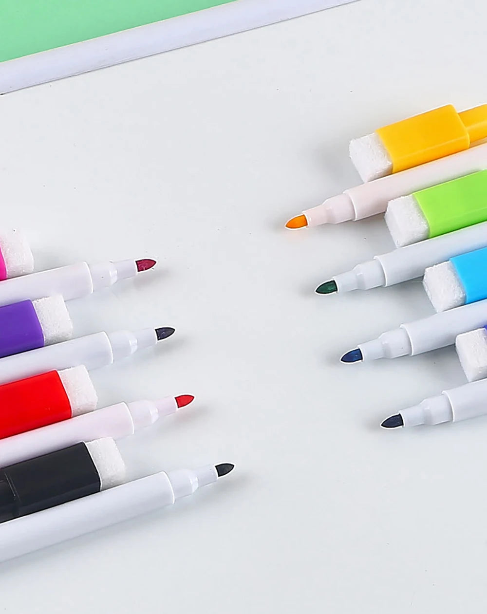 An assortment of eight magnetic whiteboard pens in various colors and tips are arranged on a white surface.