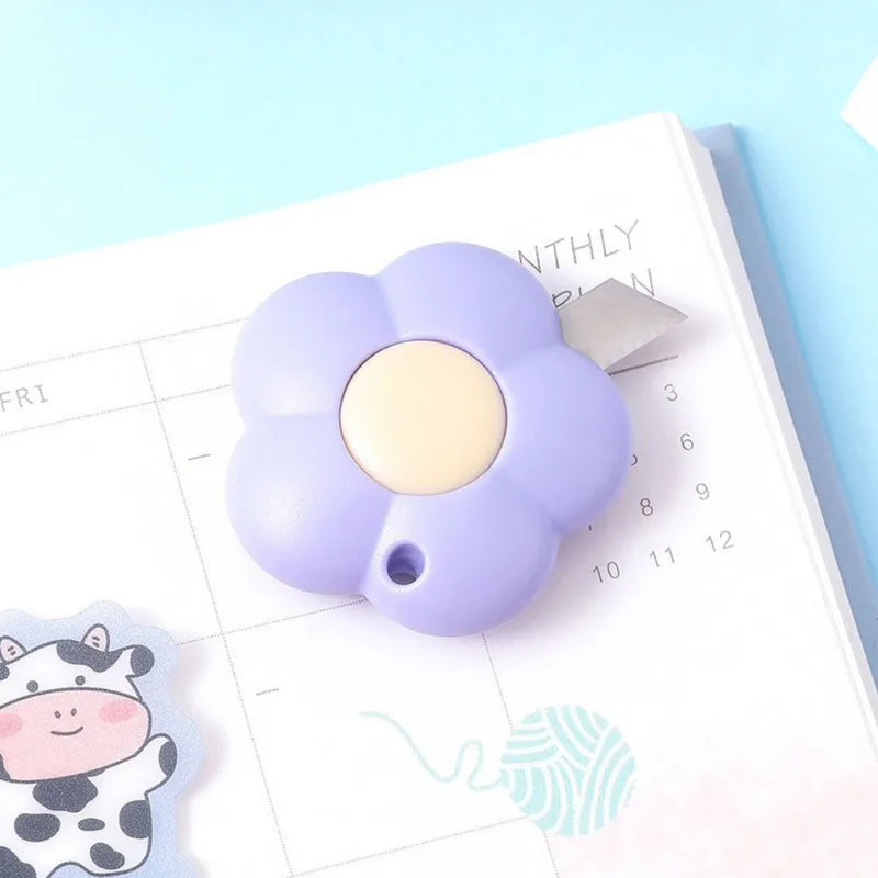 A purple floral design letter opener and paper cutter resting on a monthly planner page.