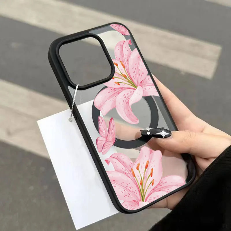 A clear iPhone case featuring a pink lily floral design with a black shockproof bumper being held by a hand.