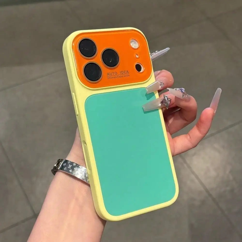 A hand holds a yellow phone case with an orange back and a teal front, featuring full lens protection.