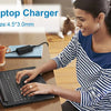A woman is using a 65W laptop charger to power a laptop on a desk.