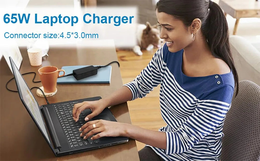 A woman is using a 65W laptop charger to power a laptop on a desk.