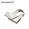 Memoria USB portátil de doble interfaz plateada y beige con diseño de clip.