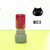 A set of three colored stamps, including a red one with a black cat pattern, is displayed on a light green surface.