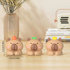 Three cute bear-shaped desk cable organizers in peach and beige colors displayed on a wooden surface.