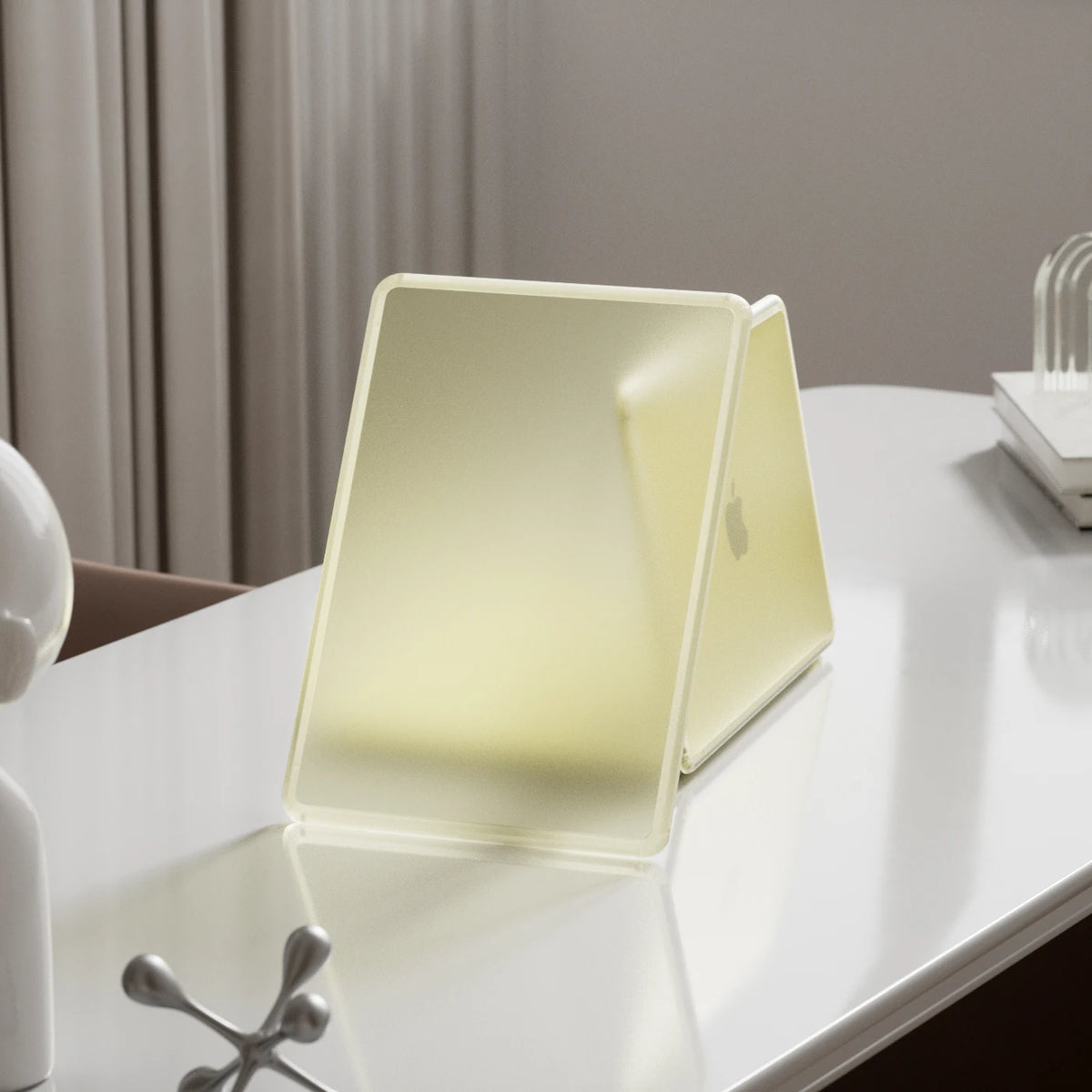 A light yellow durable hard shell laptop case for a MacBook shown on a white table.