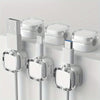 White magnetic cable management clips mounted on a white surface for organizing wires.