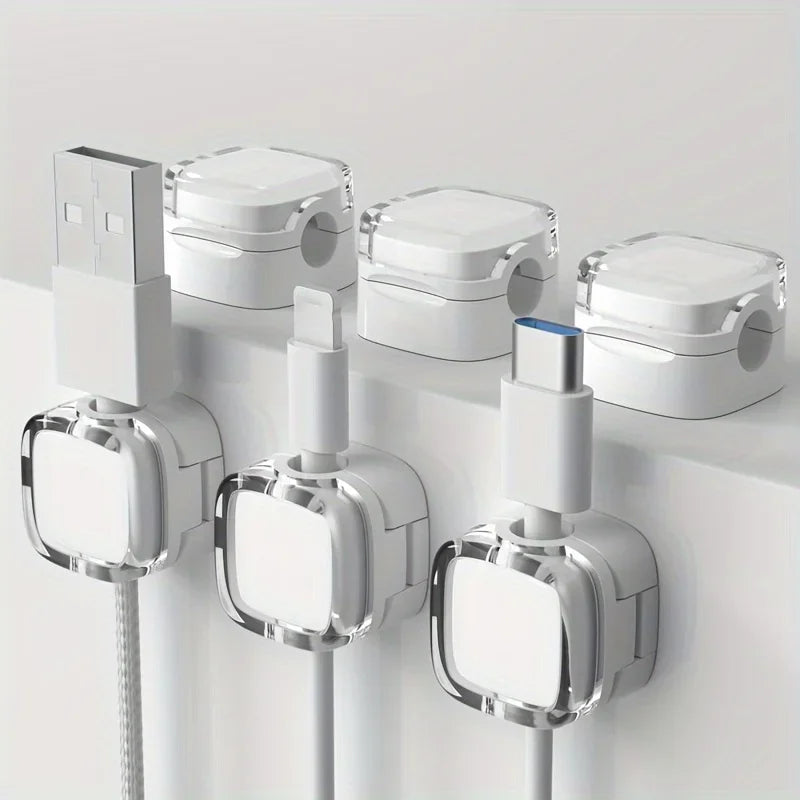 White magnetic cable management clips mounted on a white surface for organizing wires.