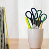 A set of black and colored stainless steel scissors displayed in a white pot.