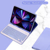 Coque iPad violette avec clavier et souris Bluetooth, sur un marbre blanc.